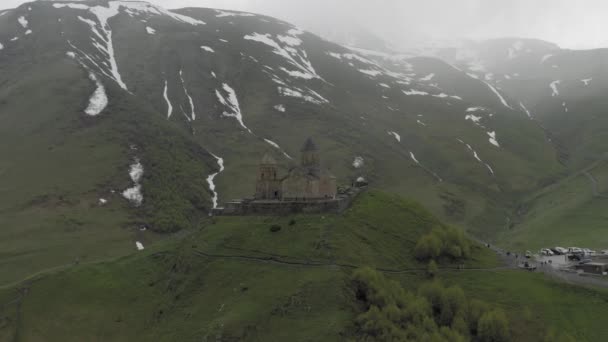 Kazberi Miuntains Gergeti Trinidad Iglesia en Georgia drone vuelo — Vídeos de Stock