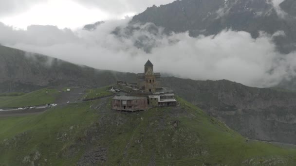Kazberi Miuntains Gergeti Trinidad Iglesia en Georgia drone vuelo — Vídeo de stock