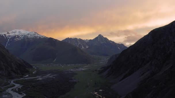 Puesta de sol en las montañas en Georgia Kazbegi y Gergeti Trinidad Iglesia norte del Cáucaso drone vuelo — Vídeos de Stock