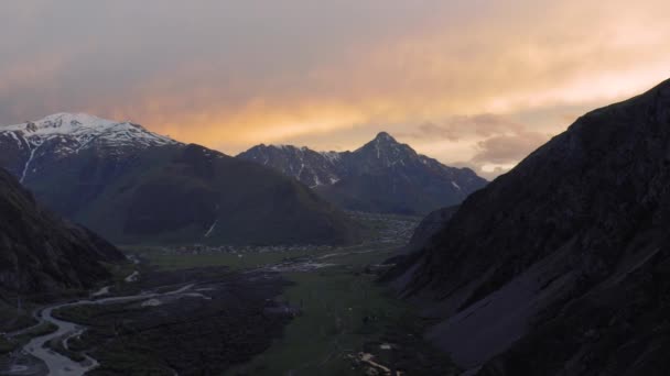 Ηλιοβασίλεμα στα βουνά στη Γεωργία Kazbegi και Gergeti Trinity Εκκλησία βόρεια Καύκασο drone πτήση — Αρχείο Βίντεο