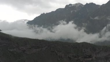Gürcistan 'daki dağlar ve bulutlar Kazbegi ve Gergeti Trinity Kilisesi Kuzey Kafkasya insansız hava aracı uçuşları