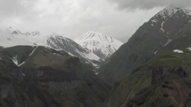 Gürcistan 'daki dağlarda kar yağdı Kazbegi ve Gergeti Trinity Kilisesi Kuzey Kafkasya insansız hava aracı