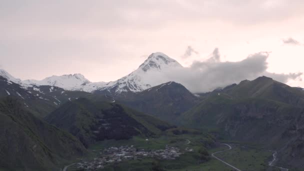 Ηλιοβασίλεμα στα βουνά στη Γεωργία Kazbegi και Gergeti Trinity Εκκλησία βόρεια Καύκασο drone πτήση — Αρχείο Βίντεο