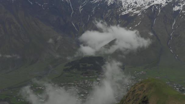 Hory a mraky v Gruzii Kazbegi a Gergeti Kostel Nejsvětější Trojice Severní Kavkaz dron let — Stock video