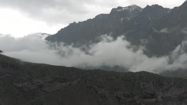 Gürcistan 'daki dağlar ve bulutlar Kazbegi ve Gergeti Trinity Kilisesi Kuzey Kafkasya insansız hava aracı uçuşları — Stok video
