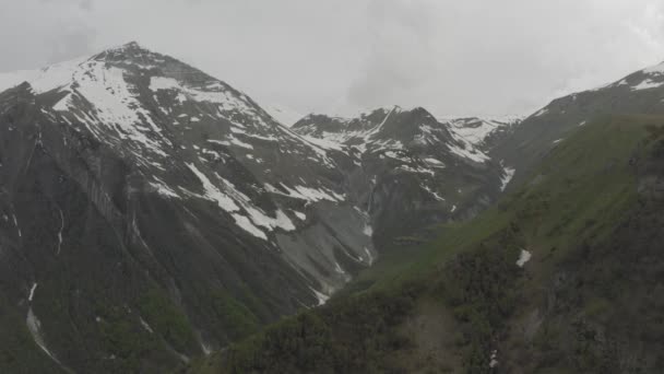 Gürcistan 'daki dağlarda kar yağdı Kazbegi ve Gergeti Trinity Kilisesi Kuzey Kafkasya insansız hava aracı — Stok video