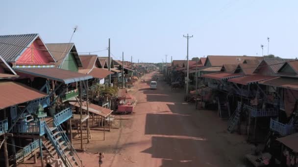 Residentiële huizen op houten palen en rode grond weg in Floating Kampong Phluk Village in Cambodja bij Tonle Sap Lake drone vlucht 4k — Stockvideo
