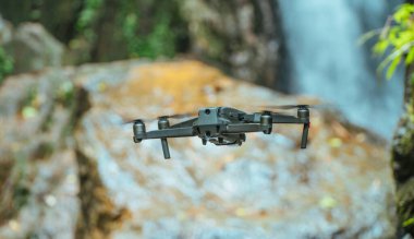 Siyah 4 motorlu Drone kuadrokopter fpv ormanda uçuyor