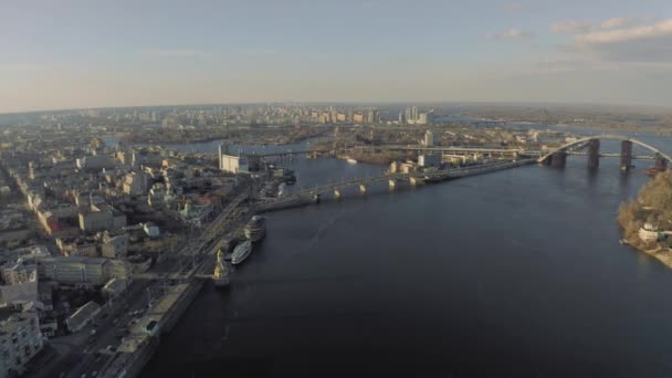 Kiev şehrindeki Dinyeper Nehri üzerindeki köprü. Güneşli bahar gününde İHA 4K uçuşu — Stok video