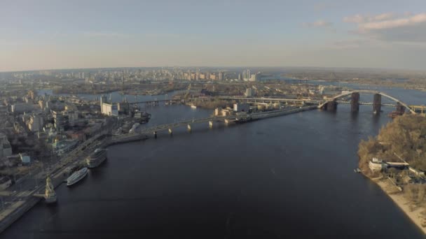 De brug over de rivier de Dnjepr in Kiev. Drone 4k fligt in zonnige lentedag — Stockvideo