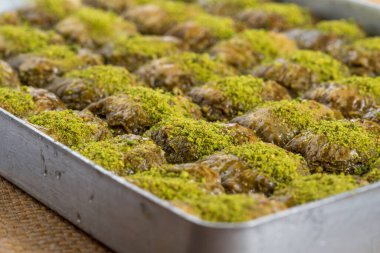 Geleneksel Türk tatlı baklavası tepside ahşap masada.