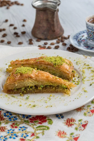 Turkish coffee and Traditional Turkish dessert baklava in plate on wooden table