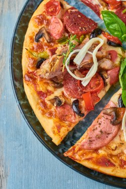 Ahşap arka planda üstten bakıldığında üstün karışık pizza..