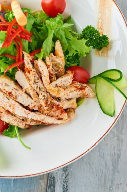 Izgara tavuk göğsü, roka ve domatesli taze salata. Üst görünüm