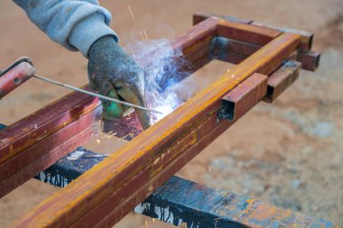 Güneşli bir günde inşaat alanında iki demir profil kaynakçısı.