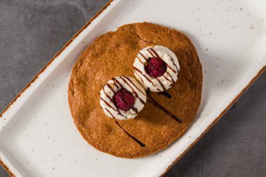 Üzerinde vanilyalı dondurma ve çikolata olan yakut kurabiyesi tatlısı.