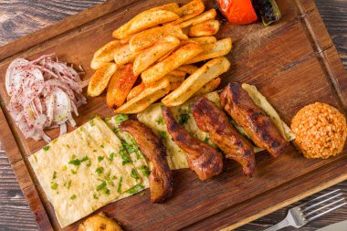 Izgara kuzu fileto ya da kızarmış patates, lavaş ekmeği ve bulgur pilavı ile servis edilen Lamb Kusleme.