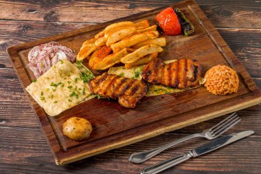 Kızartma, lavaş, soğan ve bulgur ile servis edilen kemiksiz ızgara tavuk pirzolası.