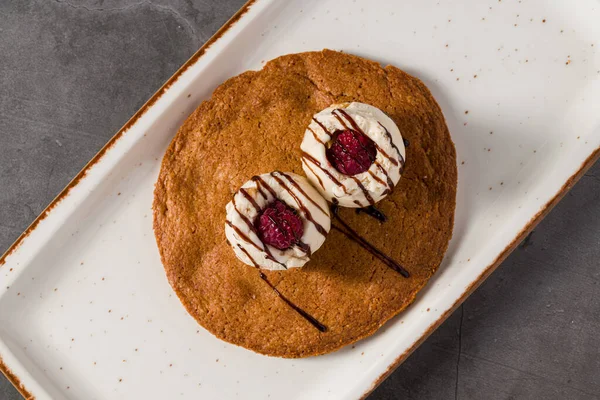 Üzerinde vanilyalı dondurma ve çikolata olan yakut kurabiyesi tatlısı.
