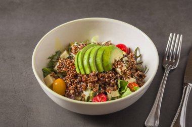 Taze kinoa salatası, avokado, vişneli domates ve karışık yeşillikler.