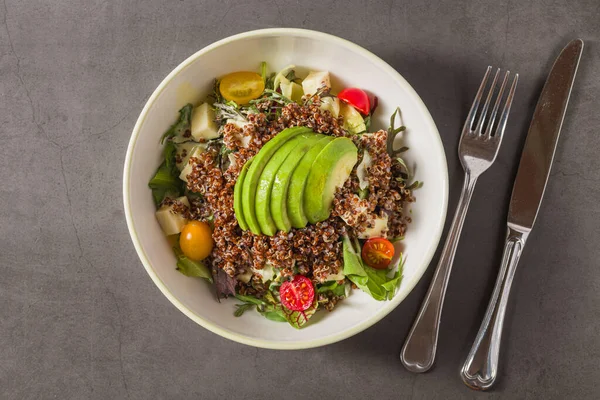 Taze kinoa salatası, avokado, vişneli domates ve karışık yeşillikler.