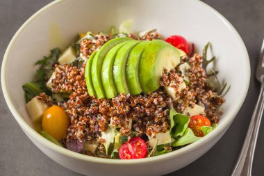 Taze kinoa salatası, avokado, vişneli domates ve karışık yeşillikler.