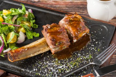 Siyah taş tabakta taze salatalı kuzu kafesi pirzolası.