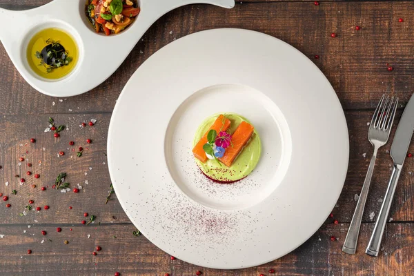 Yeşil püre ve yenilebilir çiçekli gurme somon filetosu.