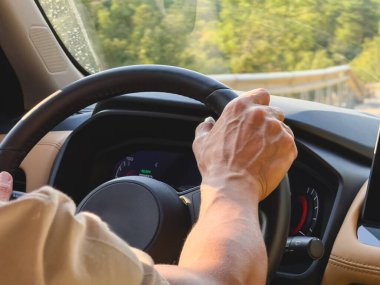 Dönek bir köy yolunda sürerken eller direksiyonu sıkıca tutar.
