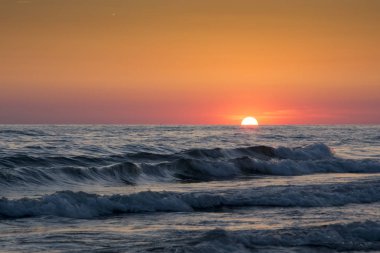 Denizin üzerindeki güzel gün batımının manzarası.