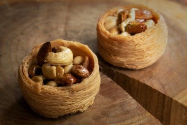 Geleneksel Arap tatlısı, ahşap tabakta fındıklı bir yuva.