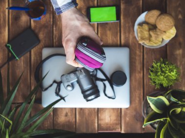 bir koruma fotoğraf makinesi çantası ahşap masa üzerinde tutan el