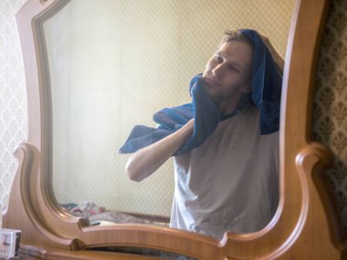 Duştan sonra havlu ile ayna önünde Genç sakallı adam