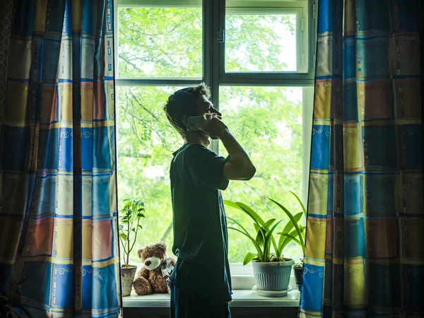 Silhueta Jovem Perto Janela Falando Com Seu Telefone Pela Manhã — Fotografia de Stock