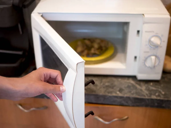 Tangan Orang Dekat Membuka Oven Microwave Untuk Memanaskan Beberapa Makanan — Stok Foto