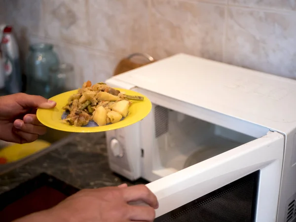 Close Hand Puts Plate Fried Vegetables Microwave Oven — Stock Photo, Image