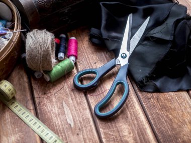 makas santimetre rulo ve ahşap bir masa iş parçacığında