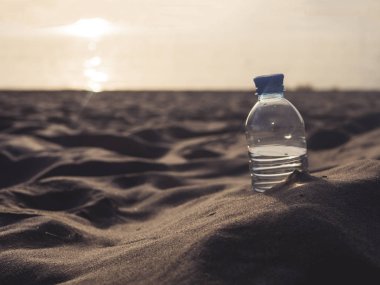 kum deniz kıyısında günbatımı şişe