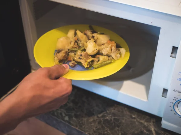Menutup Tangan Orang Menempatkan Sayuran Goreng Dalam Oven Microwave — Stok Foto