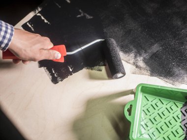 ahşap yüzey boyama silindir boyacısı aracını kullanarak siyah renk ile el kadar kapatın