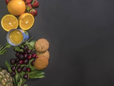 ek yükü taze çiğ tropikal ananas berry ve meyve düz siyah tablo tatlı kurabiye ile lay