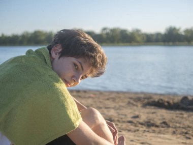 plajda havlu kopya alanı oturan genç adam portresi