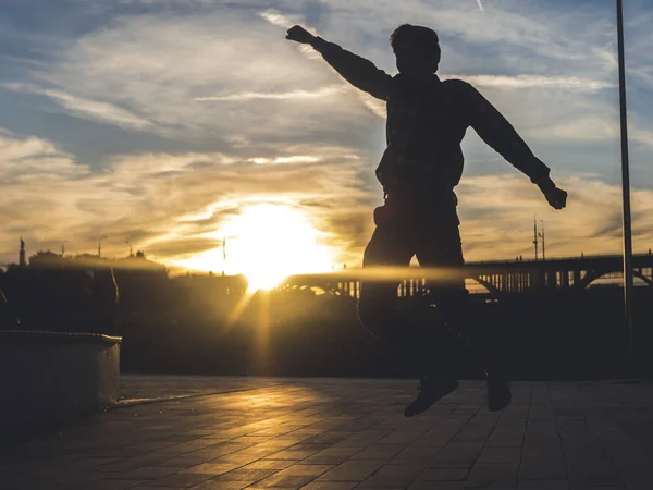 Silhueta Jovem Pulando Cidade Contra Pôr Sol — Fotografia de Stock