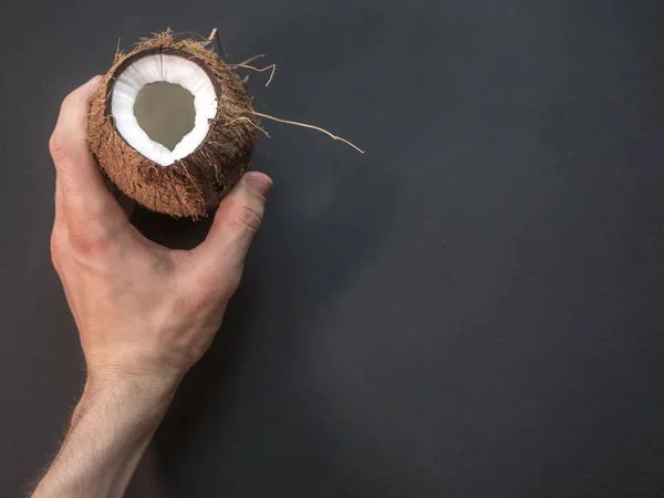 Fechar Mão Segurando Coco Quebrado Espaço Cópia Fundo Preto — Fotografia de Stock