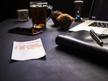 Not Defteri sayfası siyah ofis masa üzerinde tutan el kadar kapatın
