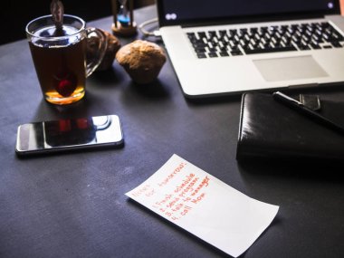 office not pad laptop telefon ve çay ile karanlık çalışma yerde
