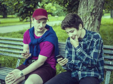 telefonları haberlerde kaydırma ve fotoğraf kontrol gülümseyen iki genç adam