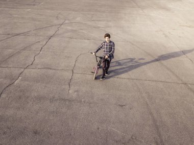 Bisiklet ile izole asfalt üzerinde yürüyen yalnız üzgün adam 