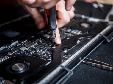 cımbız ve laptop tamiri tornavida tutan el kavramı sabitleme bilgisayarı kapatın