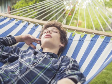 egzotik tropik sahil Hamakta yatan genç çocuk portresi